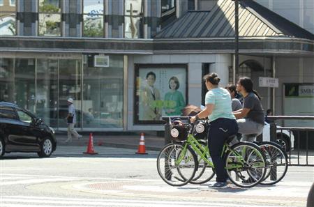 近鉄奈良駅周辺をレンタサイクルで周遊する外国人とみられる観光客。歩道を猛スピードで走ったり、道幅いっぱいに横並びで走行したりするグループもいる＝奈良市