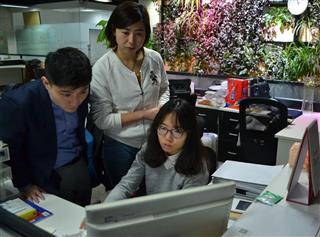 13日、北京市内のオフィスで同僚と打ち合わせをする北京国能環科環保科技の佐野史明・海外マネジャー(左) 13日、北京市内のオフィスで同僚と打ち合わせをする北京国能環科環保科技の佐野史明・海外マネジャー(左)