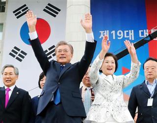 就任の宣誓を終え、韓国国会前に集まった市民に手を振る文在寅大統領(左)と金正淑夫人=10日、ソウル(聯合=共同) 就任の宣誓を終え、韓国国会前に集まった市民に手を振る文在寅大統領(左)と金正淑夫人=10日、ソウル(聯合=共同)