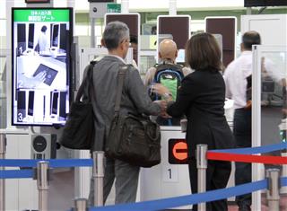 運用が始まった顔認証ゲートで、職員の説明を受ける帰国した旅客=18日午後、羽田空港 運用が始まった顔認証ゲートで、職員の説明を受ける帰国した旅客=18日午後、羽田空港