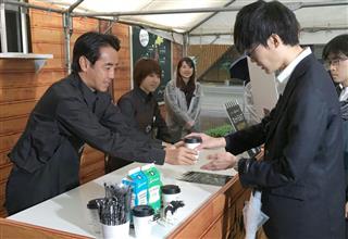 新発売のホットミルクを通行人に手渡し、PRするローソンの竹増貞信社長(左端)=10月16日、東京都千代田区 新発売のホットミルクを通行人に手渡し、PRするローソンの竹増貞信社長(左端)=10月16日、東京都千代田区