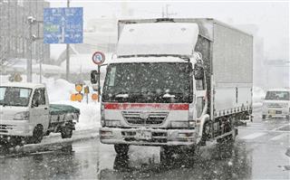 雪が降り続く中、除雪された国道8号を通行する車=13日、福井市 雪が降り続く中、除雪された国道8号を通行する車=13日、福井市