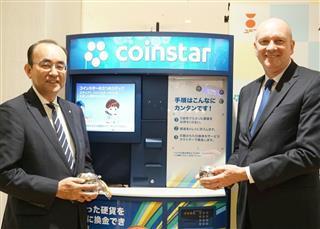コイン交換機の前で撮影に応じる佐古ユニー社長(左)とコインスター社のジム・ギャリティCEO=27日、横浜市 コイン交換機の前で撮影に応じる佐古ユニー社長(左)とコインスター社のジム・ギャリティCEO=27日、横浜市