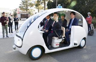 車２台を同時に走らせる自動運転システムの実証実験で、試乗する愛知県の大村秀章知事（手前左）ら＝１７日午前、愛知県豊橋市