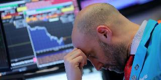 ニューヨーク証券取引所で疲れた表情を見せるトレーダー＝４日（ロイター）