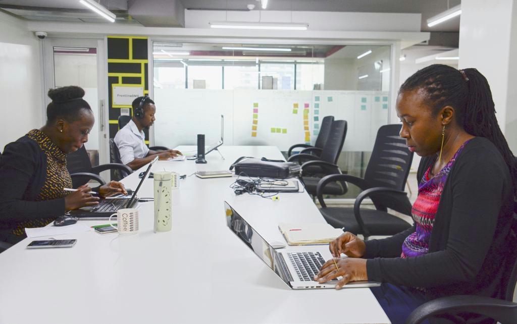 起業家支援施設の共用作業スペースで、パソコンを使って仕事をする人たち＝７月２９日、ナイロビ（共同）
