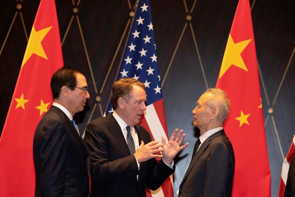 中国の劉鶴副首相（右）に話しかけるライトハイザー米通商代表（中央）＝７月、上海（ロイター）