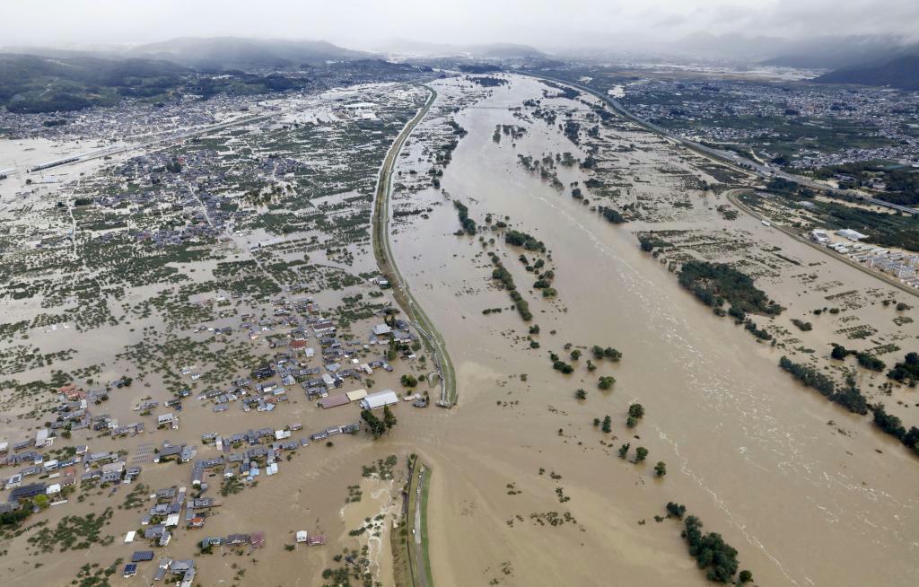 台風１９号による大雨で増水し氾濫した千曲川。中央左は決壊した堤防＝１３日午前８時１５分、長野市