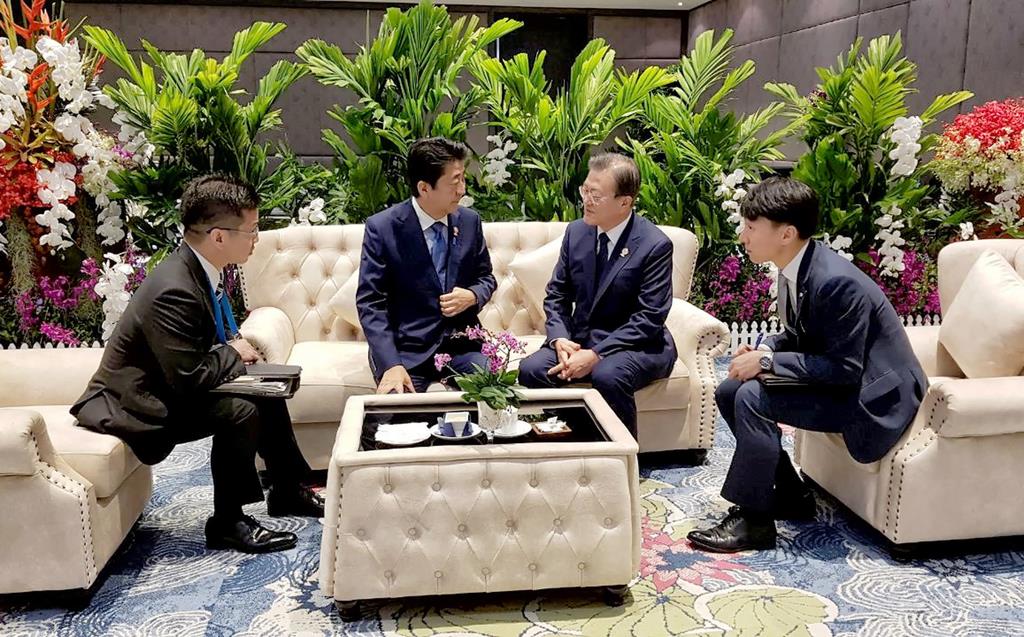 ４日、バンコク郊外で韓国の文在寅大統領（右から２人目）と話す安倍晋三首相。韓国側が日本側に無断で撮影、公表した（韓国大統領府提供・聯合＝ロイター）