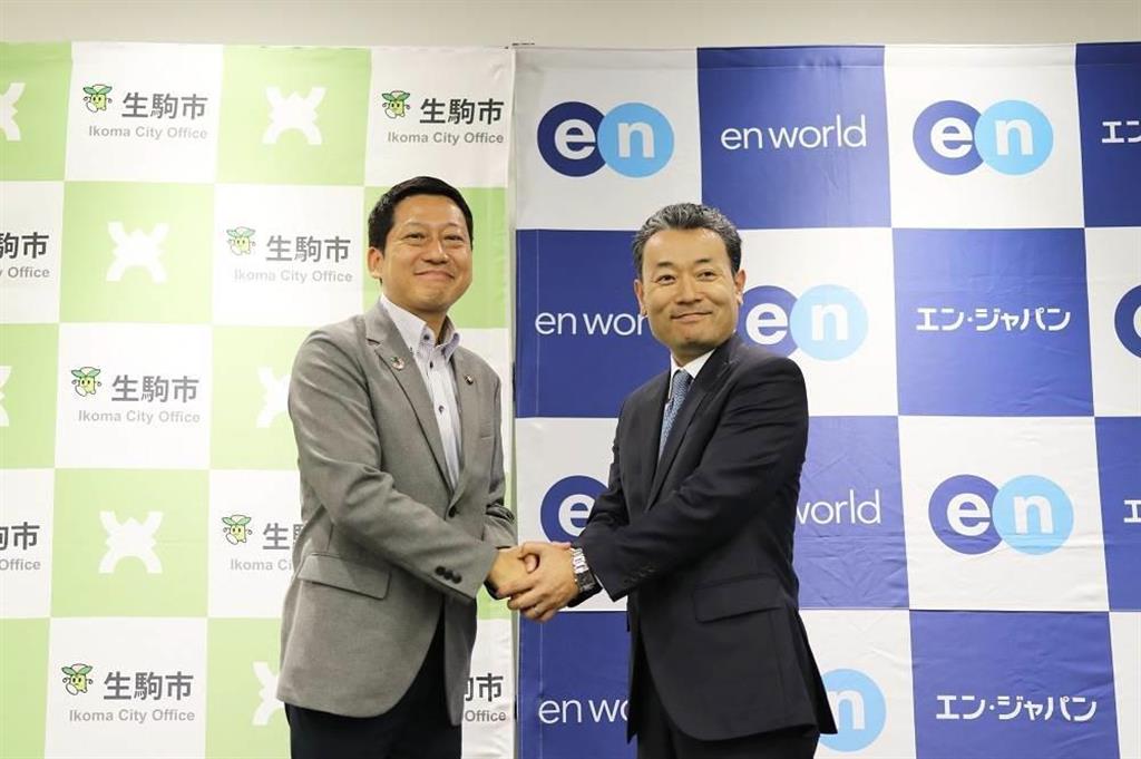 エン・ジャパンと連携協定を結び、同社の鈴木孝二社長（右）と握手を交わす小紫雅史市長（同社提供）
