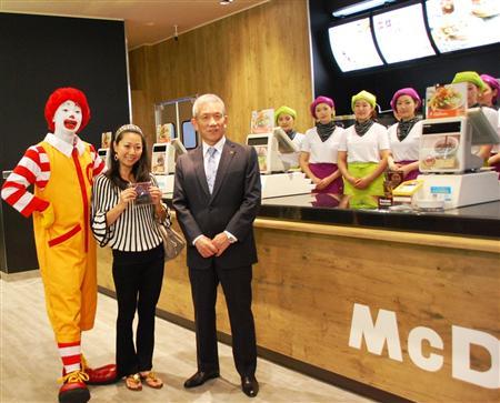 新店の最初の客と記念撮影する日本マクドナルドの原田泳幸ＣＥＯ（右）＝２９日、東京都渋谷区