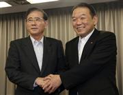 記者会見後に握手を交わすヤマダ電機の山田昇会長（左）とベスト電器の小野浩司社長＝１３日午後、東京・大手町