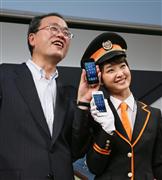 ｉＰｈｏｎｅ５発売開始を祝うイベントでポーズをとるＫＤＤＩの田中孝司社長と剛力彩芽＝２１日午前、東京都渋谷区（小野淳一撮影）