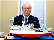 支援に対する感謝のしるしとして、気仙沼市から贈られた漁船の模型を披露する碇社長