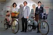 電動アシスト自転車「ＰＡＳ」の新シリーズを紹介するヤマハ発動機の柳弘之社長（中央）＝１４日、東京都新宿区