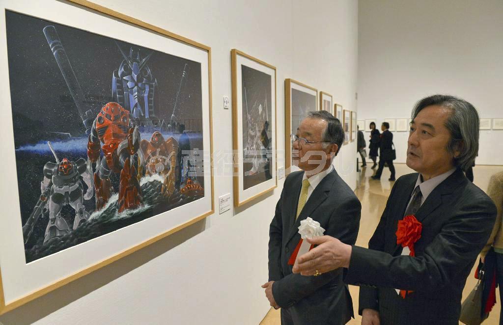 兵庫県立美術館の蓑豊・館長（左）に機動戦士ガンダムのポスターの原画について説明する大河原邦男さん＝２２日午後、神戸市中央区（甘利慈撮影）