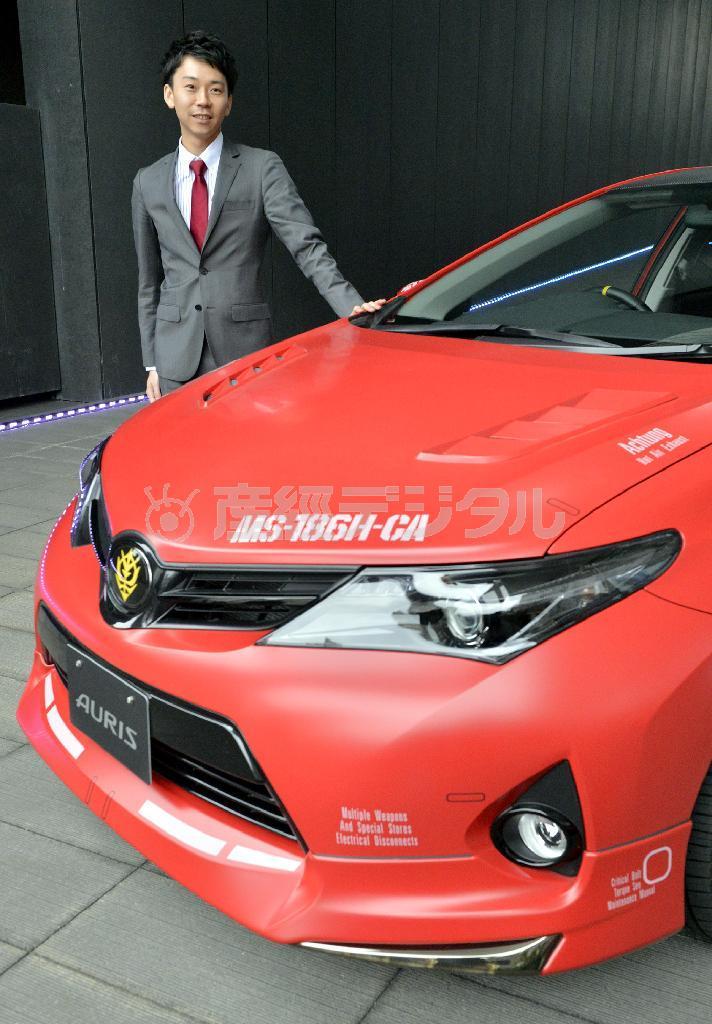 シャア専用オーリスと、企画したトヨタマーケティングジャパンの柳澤俊介さん＝神戸市中央区の兵庫県立美術館（甘利慈撮影）