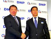 業務提携を結んだ大日本印刷の閑郁文デジタルサイネージ推進本部長（右）と、クァンタコンピューターの長安弘勲ＬＣ事業部営業部長＝３日、東京都品川区