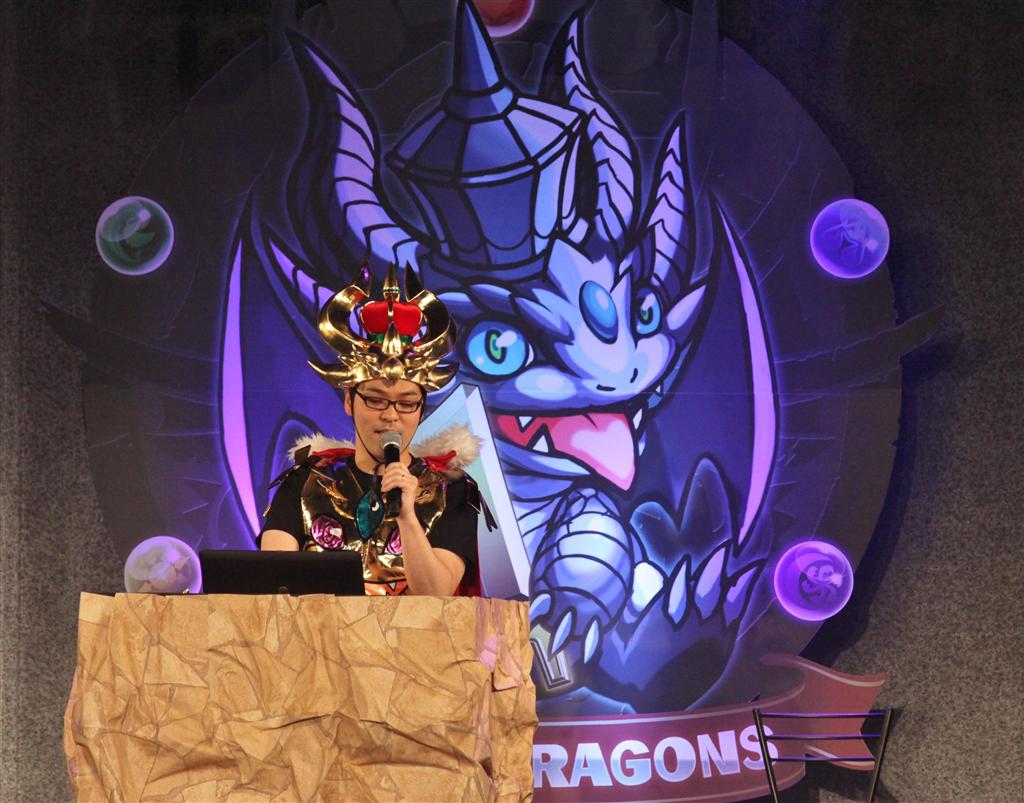 人気ゲーム「パズル＆ドラゴンズ」のイベントでステージに立つ、プロデューサーの山本大介氏