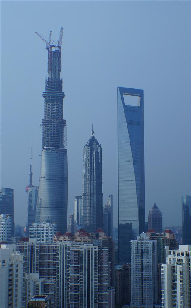 上海市の国際金融センター地区で８月初めに、まず高さ５８０メートルの本体構造が完成した高層ビル「上海中心大厦」（左）。中央は「金茂大厦」（４２１メートル）、その右隣が「上海環球金融センター」（４９２メートル）＝８月１１日、中国・上海市（河崎真澄撮影）