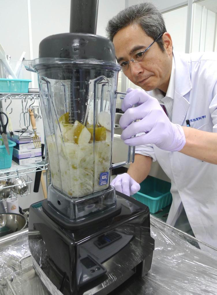 福島産のナシをジューサーにかけ、放射能を測定するイオングループの生活品質科学研究所スタッフ＝千葉市美浜区