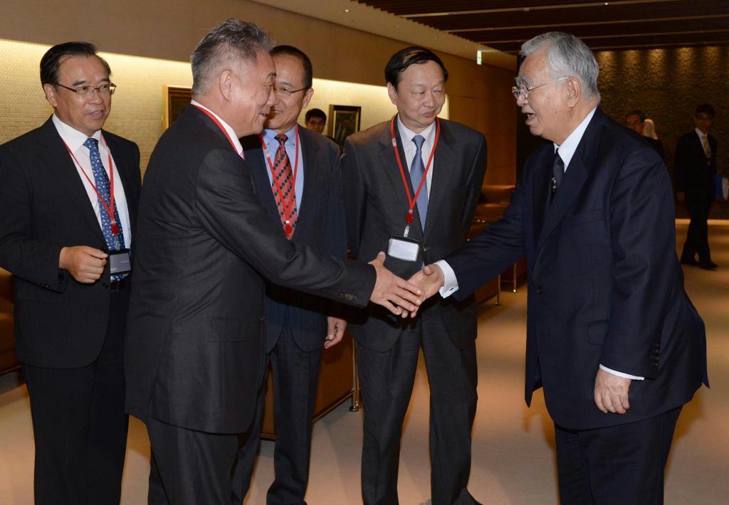 中国中信集団の常振明会長（右から２人目）らを握手で出迎える、経団連の米倉弘昌会長（右端）＝２５日、東京都千代田区