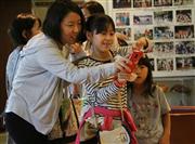 スマートフォンの画面に映るキャラクターの解説を楽しむ参加者＝２６日、種子島