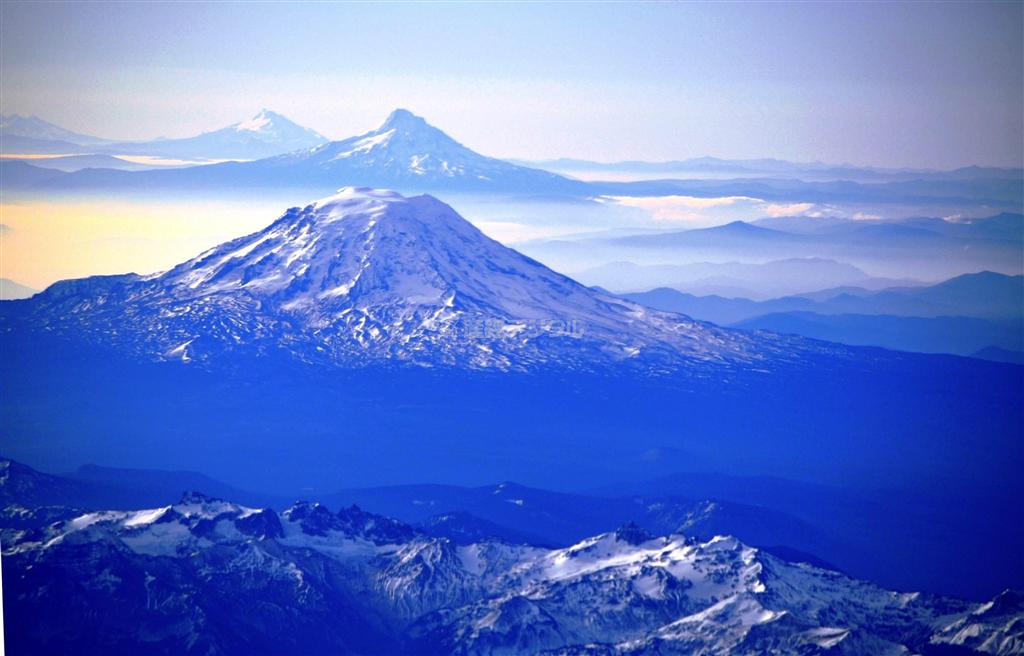 米コロラド州デンバーからワシントン州シアトルに向かい、飛行機が降下を始めるころ、左側の窓からカスケード山脈の山々が見えてくる。手を伸ばせば届きそうな近さにあるのがレーニエ山、その後ろにアダムス山と１９８０年に大爆発したセントへレンズ山、さらに遠くにフッド山がある。レーニエ山は唐木英明学長お気に入りの山の一つ＝２００９年１１月５日（唐木英明さん撮影）