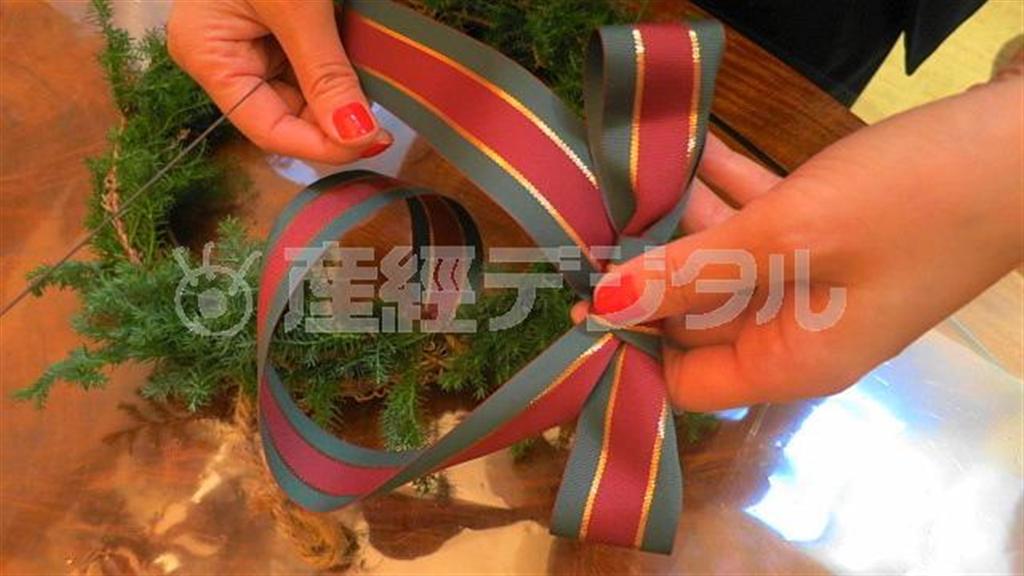（手順２）リースの頂上にあたる部分に蝶結びしたリボンをワイヤで留めます（提供写真）