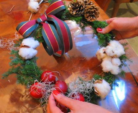 （手順４）最後にコットンフラワーとシルバーモスをアクセントとしてあしらい、リースにグルーガンで留めます（提供写真）