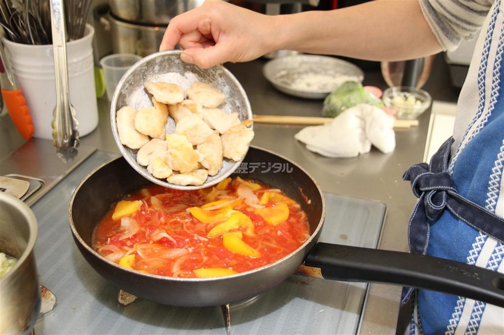 鶏むね肉のトマト煮（作り方２）＿＿フライパンに残りの油とにんにくを熱し、香りが立ってきたらたまねぎを炒める。しんなりとしたらトマト缶と水、コンソメを加え、煮たったら（作り方１：フライパンに半量の油を熱し、塩・白ワインを振り、小麦粉をまぶした鶏肉の両面を焼いて取り出す）とパプリカを加える。なじんだら、ブロッコリーを加え、塩・こしょうを加えて味を調える（今泉有美子撮影）