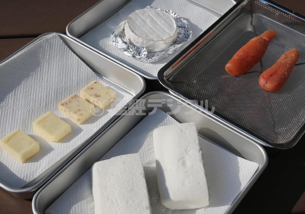 今回の材料はこちら。奥から時計回りにカマンベールチーズ、タラコ、切れ目を入れてチーズを挟んだはんぺん（塩をふっておく）、プロセスチーズ。分量は網に乗るだけ！。★ポイント１＝いずれも乾燥させるため、キッチンペーパーに乗せ、冷蔵庫から出して約１時間置く。★ポイント２＝はんぺんからは表面からも水分が出るので、キッチンペーパーで拭いておく