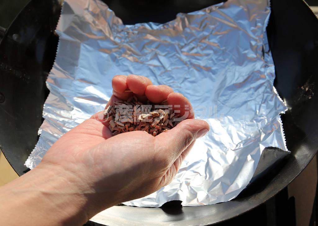 （手順１）中華鍋にアルミホイルを敷き、チップをひとつかみのせる。★ポイント＝チップの量は多すぎるといがらっぽくなってしまうので注意！目安は燻製時間１０分につきひとつかみ。熱を通す必要のない素材は１０分程度燻製するだけで十分香りがつく（宮崎裕士撮影）