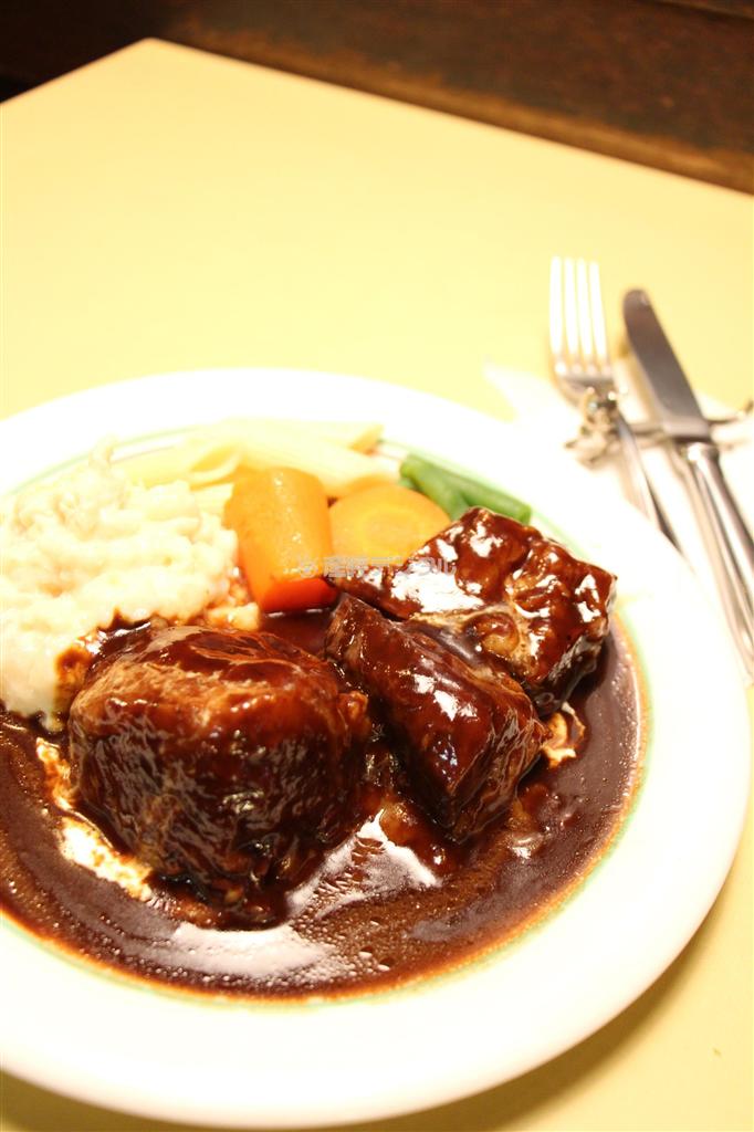 お皿の真ん中には堂々の牛バラ肉。つやつや輝くソースをかけて。名物料理ビーフシチューは著名人の舌もうならせる。