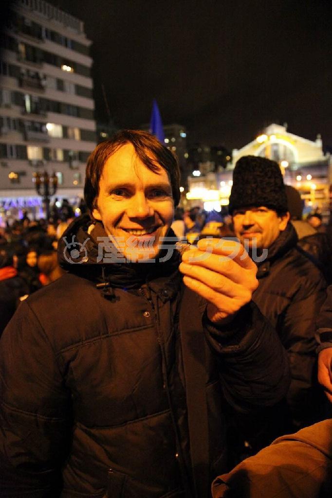 首都キエフ中心部でなぎ倒されたウラジーミル・レーニン像の破片を手にする男性＝２０１３年１２月８日夜、ウクライナ（佐々木正明撮影）