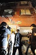家宅捜索のため容疑者の自宅に入る捜査員ら（最上階右上が容疑者の部屋）＝２０１３年１２月１６日午後７時３８分、大阪市東成区（沢野貴信撮影）