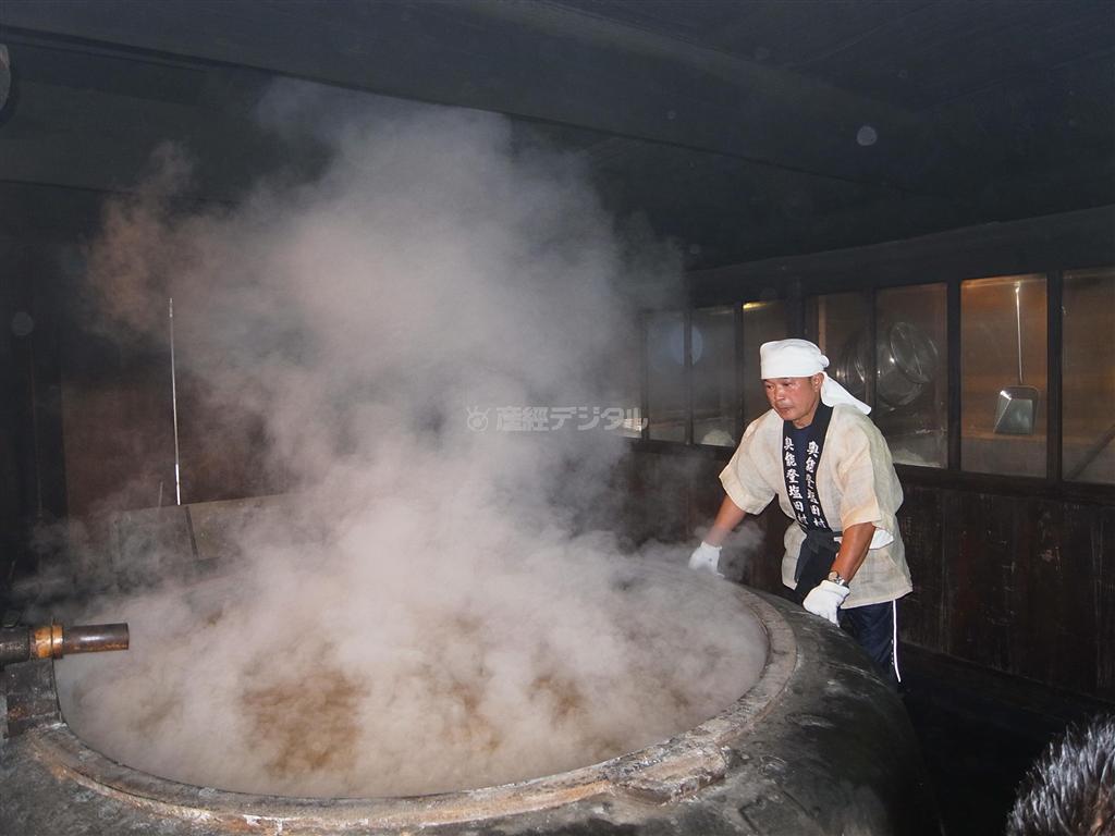「奥能登塩田村」の浜氏・登谷良一さん。室温６０度の釜屋の中で、釜焚きの火加減を調整しながら塩作りを行う＝石川県珠洲（すず）市（杉山みどり撮影）