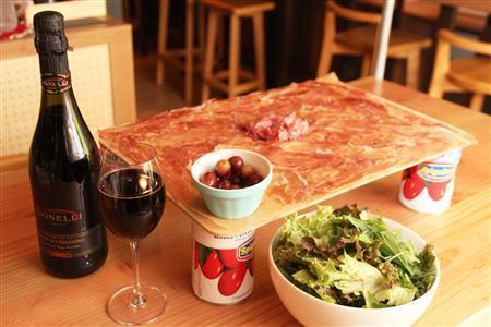 根強いファンが多い「元祖！生ハムとサラミのてんこ盛り」（１２８０円）。一緒にイタリアの微発砲ワイン「ランブルスコ」を楽しむのが“ディプント流”