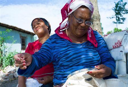 毎日のように観光客が訪れるトリニダ近郊のイスナガ。お土産用に多くの女性たちが刺繍（ししゅう）に励んでいた。後ろに見えるのが彼女たちの家らしく「こんな家に住んでんのよ。いくらか恵んでよ」と窮状を訴えてきた＝キューバ（緑川真実さん撮影）