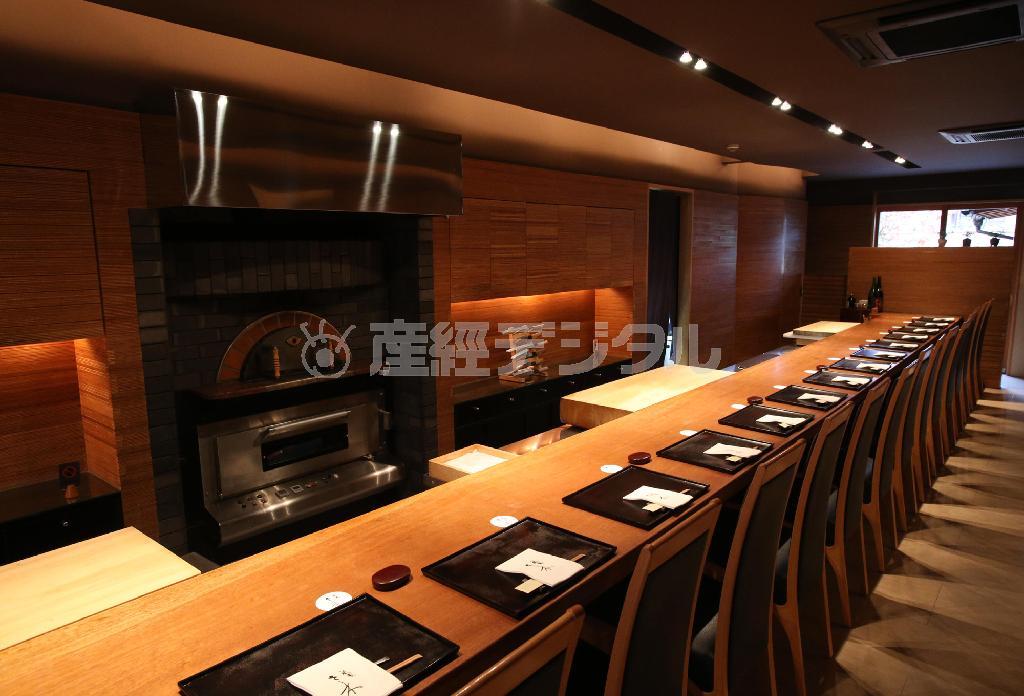 約１０メートルのマホガニーの一枚板でできたメーンのカウンター席（全１７席）。中央には何と「ピザ窯」も＝２０１３年１２月１８日、京都市東山区（恵守乾撮影）