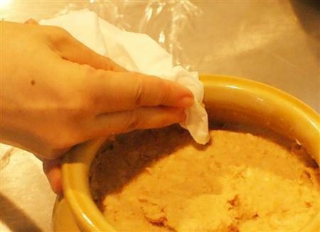 ＜みそ作りに挑戦＞＿＿（工程９）ふちについたみそを、アルコールをふくませたキッチンペーパーで拭き取る（塩塚夢撮影）