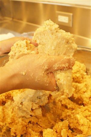 ＜みそ作りに挑戦＞＿＿（工程６）ゆで汁（ぬるいぐらいの温度）を加えて堅さを調整する。握って指の間から出るぐらいになればＯＫ（塩塚夢撮影）