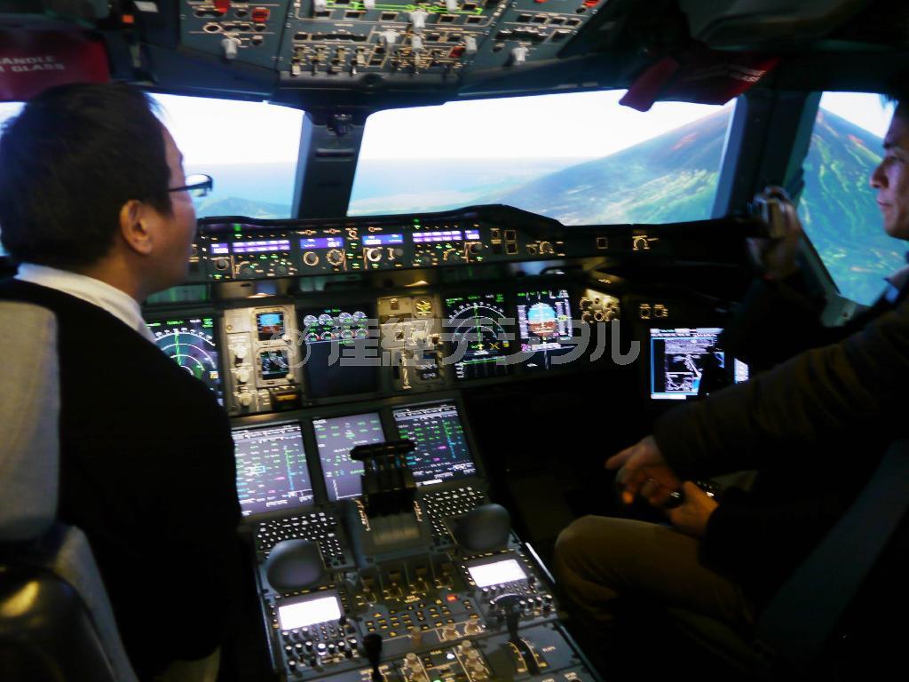 世界最大の旅客機エアバスＡ３８０のシミュレーターで、日本上空の操縦体験をする日本人の記者たち。画面右は、富士山＝２０１３年１２月１１日、フランス・トゥールーズのエアバス本社（内藤泰朗撮影）