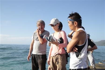 海辺で撮影の打ち合わせをする河瀬直美監督（中央）。作品では、美しい、時に荒々しい姿をみせる自然を切り取った＝２０１３年１０月１９日、鹿児島県・奄美大島（アスミック・エース提供）。（Ｃ）２０１４“ＦＵＴＡＴＳＵＭＥ＿ＮＯ＿ＭＡＤＯ”ＪＦＰ，ＣＤＣ，ＡＲＴＥ＿ＦＣ．