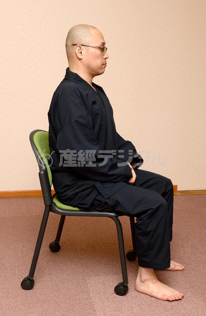 （座禅の基本動作【お手本】）日常生活で取り入れやすいのは「椅子座禅」。膝の角度は直角で、足は肩幅ぐらいに開く。足の裏をきっちりと床に付ける。背筋を伸ばす。手を組んで、呼吸を意識する（大山実撮影）