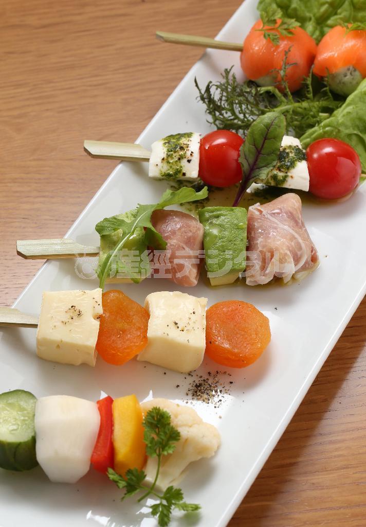 「前菜ミニブロシェット五種」（１１８０円）。自家製ピクルスをはじめ、クリームチーズとレモン、ケイパーとデイルを刻んだものがスモークサーモンに巻かれている串もあり、見た目も味わいも楽しい冷製の前菜