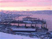 つかの間の薄明に照らされるムルマンスク港と市街。人口流出と経済低迷に悩んだ「極夜」の町は、海氷の減少によって一転、熱気が漂う港町に変身した＝２０１３年１２月９日、ロシア・ムルマンスク州ムルマンスク市（遠藤良介撮影）