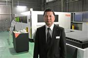 ファイバーレーザ切断機を導入したレーザマックス・小野雅夫専務は、ＣＯ２レーザ切断機に比べての優位性を述べる