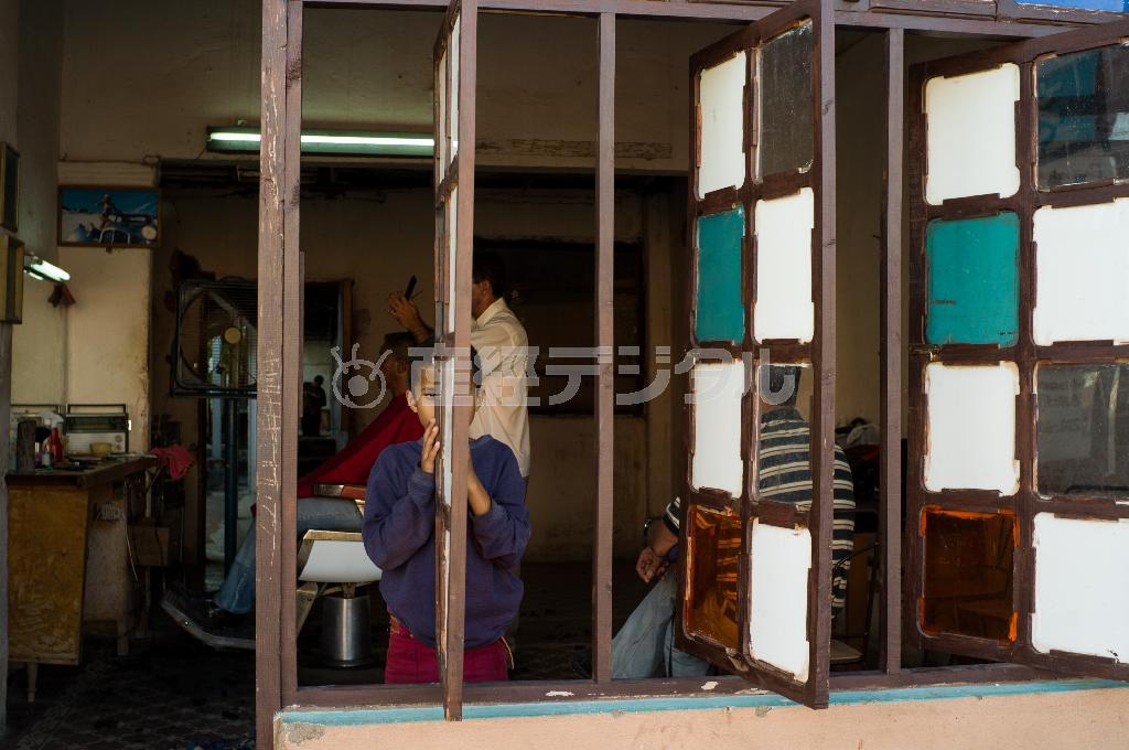 トリニダの床屋さんで、窓枠からじっと見つめる少年が面白くて、私もそーっとシャッターをきる＝キューバ（緑川真実さん撮影）