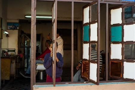 トリニダの床屋さんで、窓枠からじっと見つめる少年が面白くて、私もそーっとシャッターをきる＝キューバ（緑川真実さん撮影）